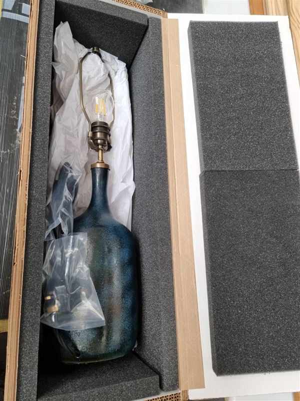 A finished blue lamp packed in a foam-lined box for shipping overseas