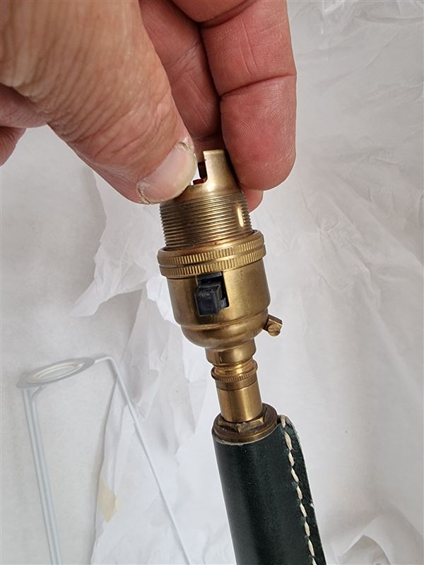 Brass switched lampholder on a green stitched-leather lamp stem
