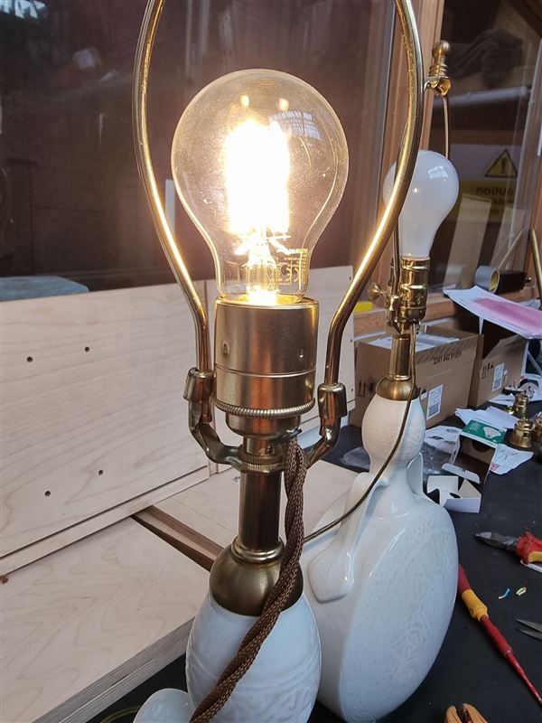 The same porcelain lamp converted to British fittings with a brown fabric flex, switched on