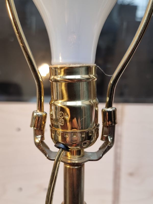 Close-up of the original American lampholder and flex on a white porcelain lamp